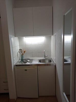 Studio (A1) | Privékeuken | Een koelkast, een kookplaat, een waterkoker, kookgerei, borden en bestek