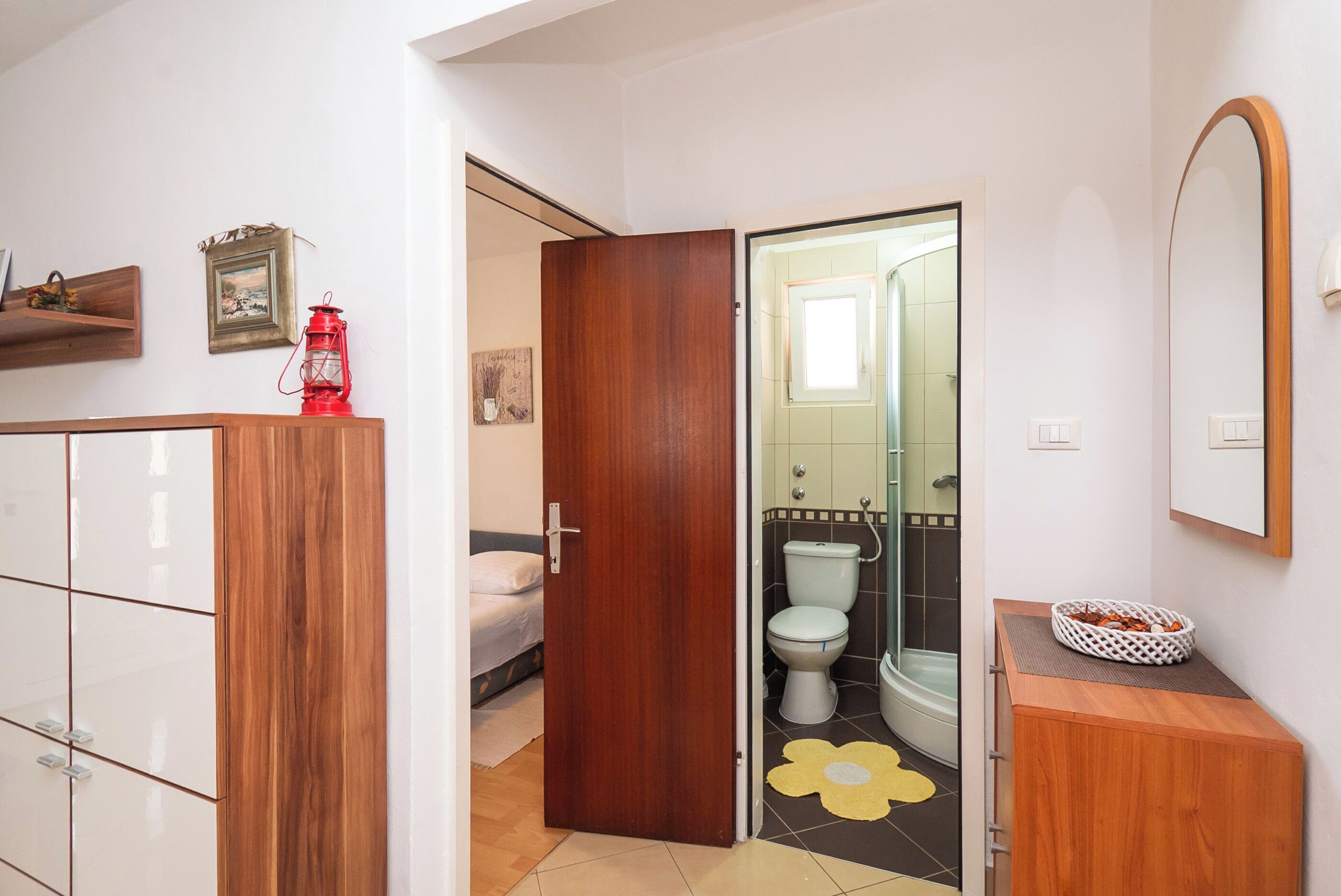Une salle de bain avec des toilettes, une douche et un meuble en bois.