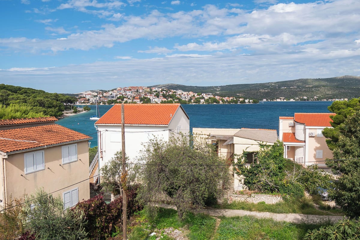 A coastal town with buildings along the waterfront, a clear sky, and a view of the sea.