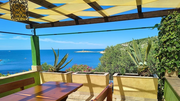A wooden bench and table under a pergola with a view of the sea and distant island. - House Villa Carmen (Rogoznica)