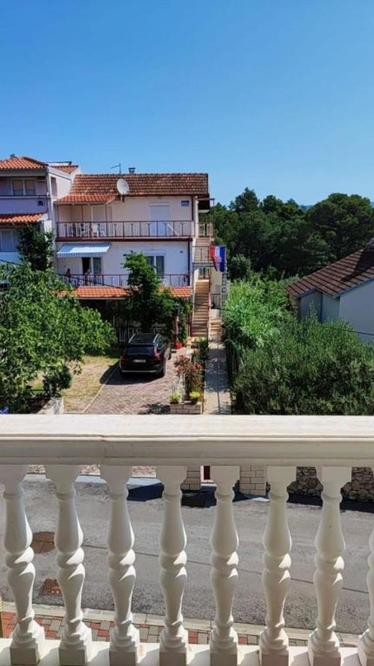 Un edificio residencial con techo de tejas, antena parabólica y balcón.