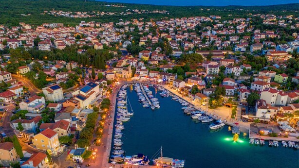 An aerial view of a coastal town with a marina filled with boats, surrounded by residential buildings and greenery. - Apartment Neo (Malinska-Dubasnica)