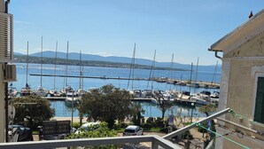 A marina with multiple boats docked, a clear sky, and a mountainous backdrop. - Apartment Neo (Malinska-Dubasnica)