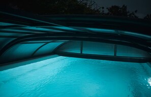 Una piscina con techo curvo e iluminación azul.
