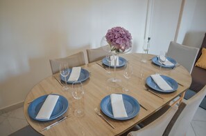 A round dining table with blue plates, white napkins, and wine glasses. - House Mili (Zagvozd)