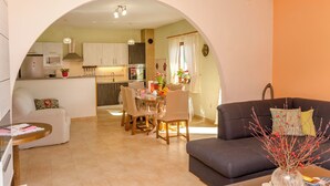 Un espacio abierto que combina sala y comedor, con un sofá, una mesa de comedor y sillas.