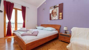 Un dormitorio con una cama de madera, una mesita de noche, una lámpara y un cuadro en la pared.