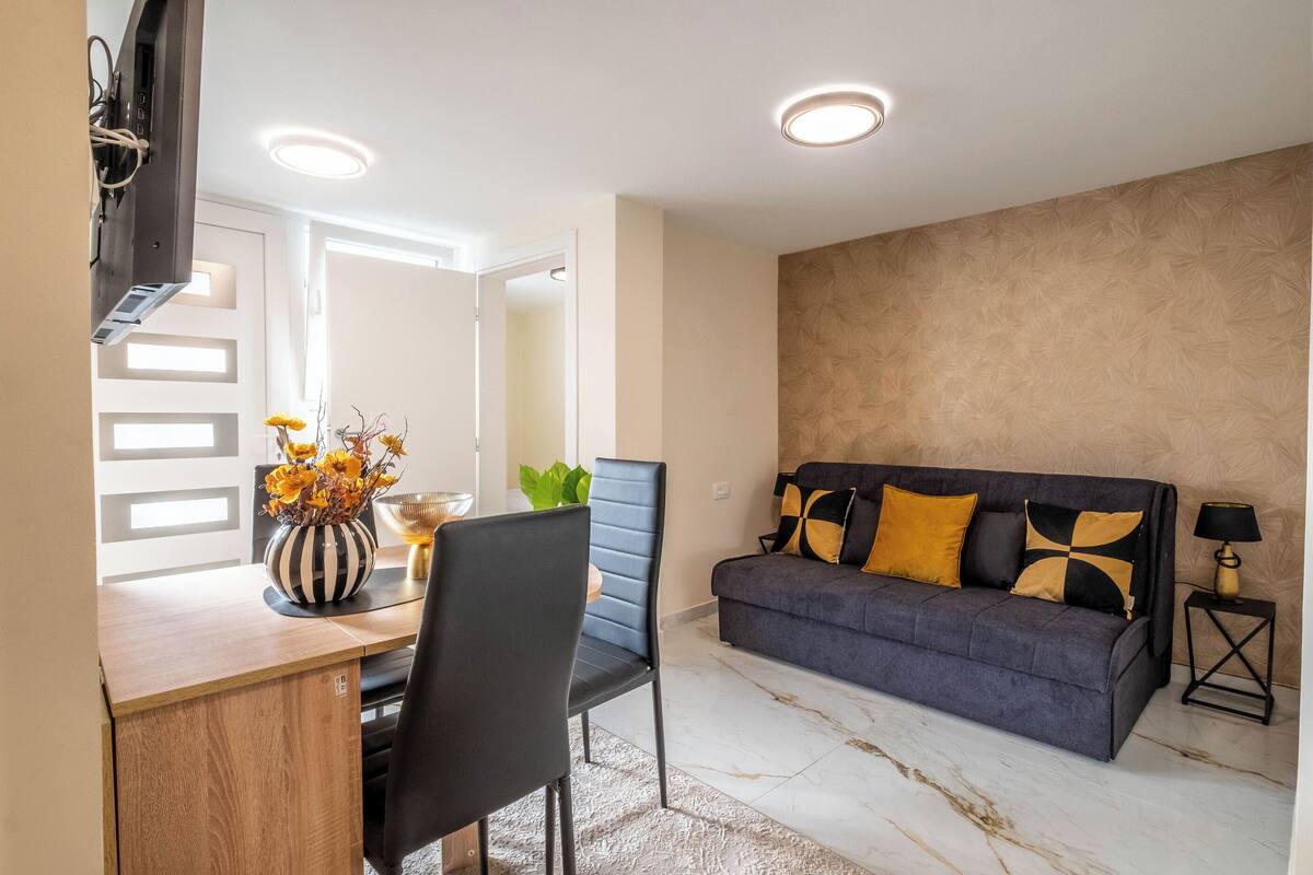 A modern living room with a sofa, a dining table, and a chair.