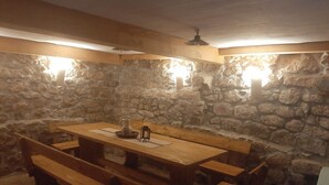 A stone-walled room with a wooden table and benches. - House Dragica (Vinodol)