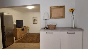 A compact kitchen with a refrigerator, a television, and a wooden cabinet. - House Dalmatika Zaton (Nin)