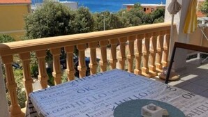 A balcony with a view of the sea, a newspaper spread on the floor, and a small object on the newspaper. - Apartments Mare Family Only (Kolan)