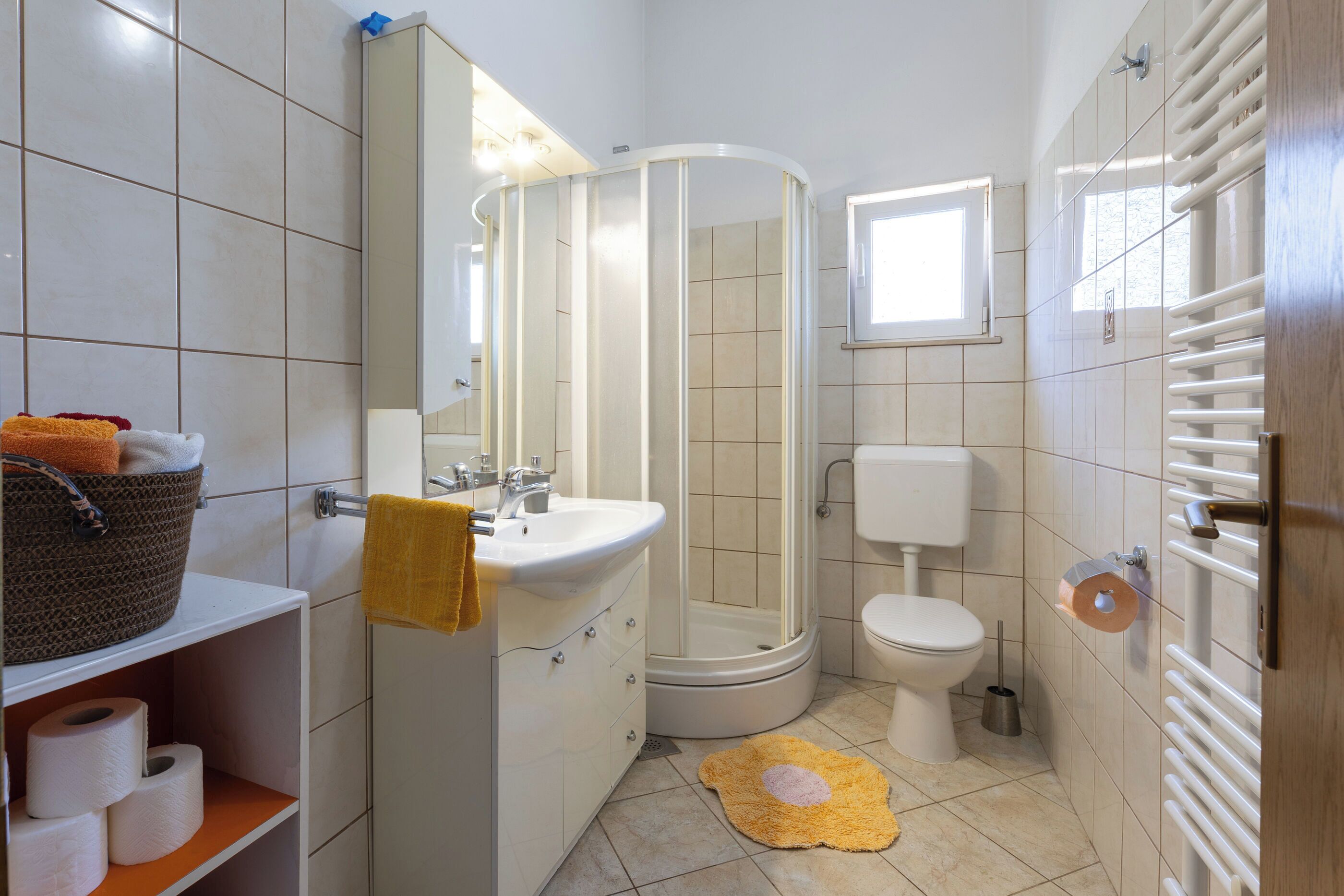 Une salle de bain équipée d’une douche, de toilettes, d’un lavabo et d’un porte-serviettes.