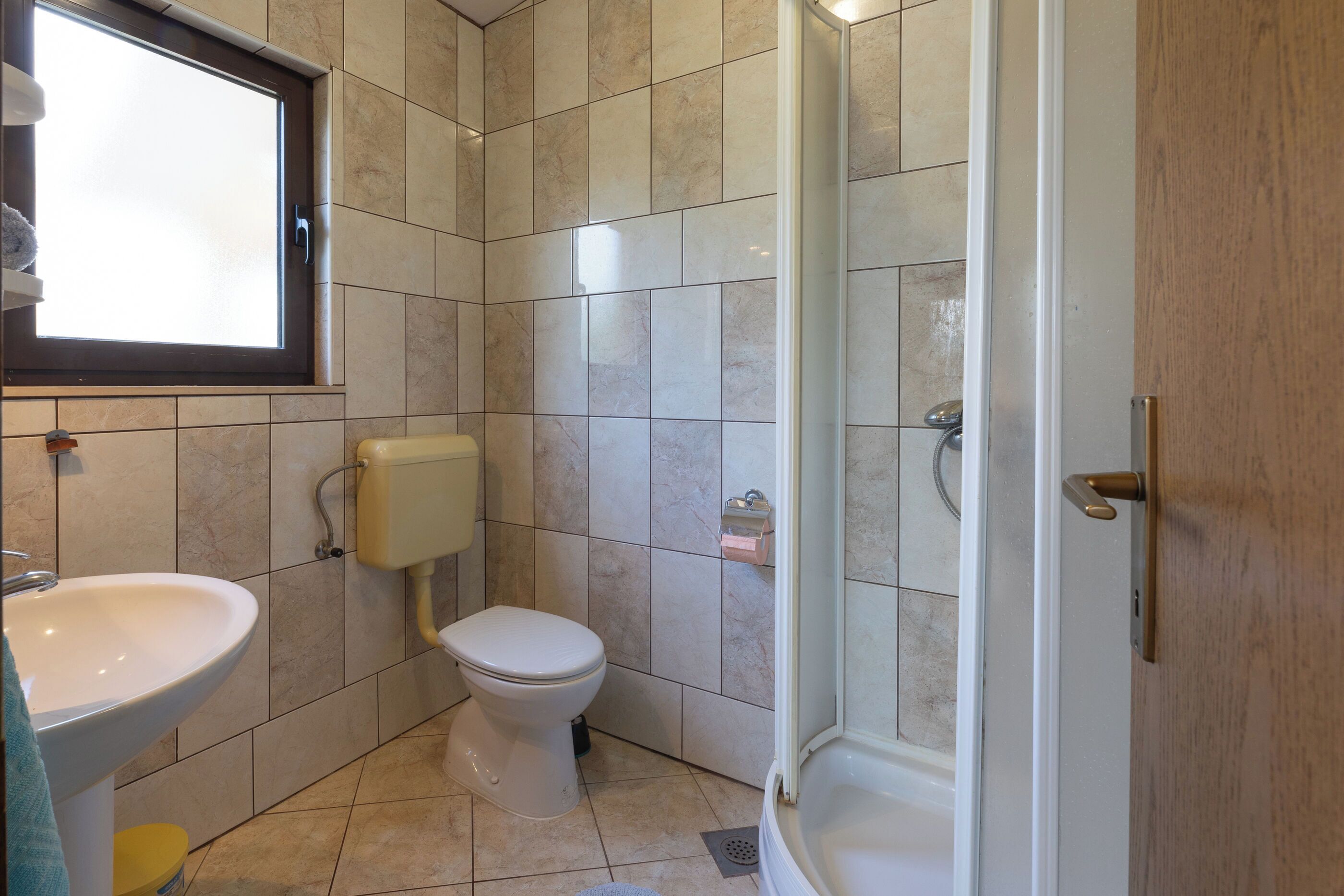 A bathroom with a sink, toilet, and shower.