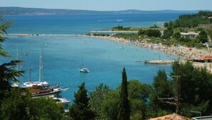 A coastal town with a marina, beach, and residential buildings. - Apartment Ivana (Omis)