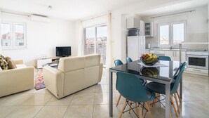 Eine moderne Wohnung mit Wohnzimmer, Essbereich und Küche.