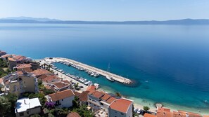 Une ville côtière dotée d’un port de plaisance, d’eaux d’un bleu limpide et de bâtiments à étages.