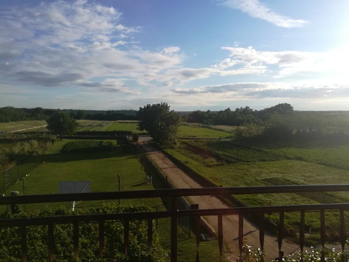 Un paisaje rural con un puente, campos y cielo despejado.