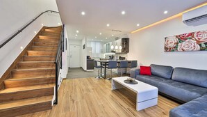 A modern living room with a staircase, a dining area, and a kitchen. - Apartment Silva (Split)