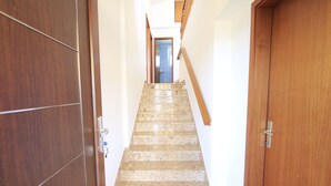 A staircase with wooden handrails and a door on the right. - House Gianna (Sveti Filip i Jakov)