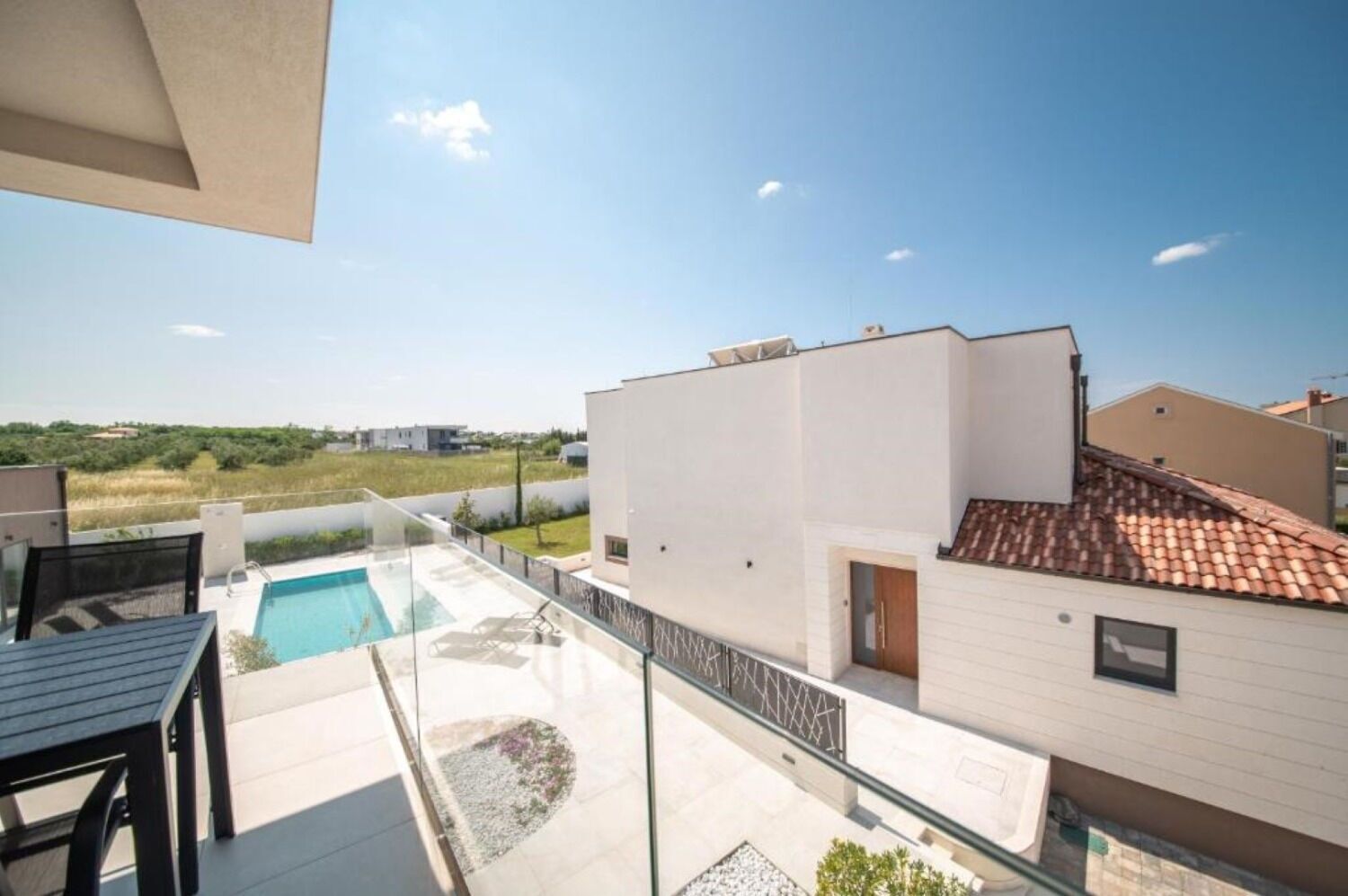A modern apartment with a rooftop pool, a terrace, and a view of the surrounding landscape.