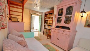 Un salon confortable avec un canapé, un meuble et une bibliothèque.