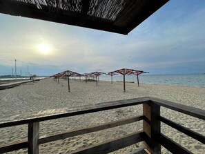 A beach with wooden structures and a wooden railing. - Apartment Punta (Nin)