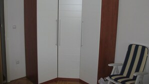 A corner wardrobe with two doors and a chair. - Apartment Milan (Trogir)