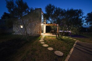 A stone building with a paved pathway leading to a covered outdoor seating area. - House Stone House With Jacuzzi (Preko)