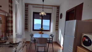 A kitchen with a dining table, chairs, a stove, and a refrigerator. - Apartment Anchi (Novi Vinodolski)