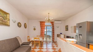 A compact living space with a sofa, dining table, and kitchen area. - Apartments Angel (Vodice)