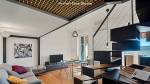 A modern living room with a sofa, a dining table, and a TV. There is a staircase with a unique design and a view of the outdoors. - La Scala Matta, Sea Lands (La Spezia)