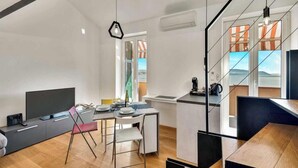 A modern living space with a dining area, kitchen, and a large window offering a view. - La Scala Matta, Sea Lands (La Spezia)
