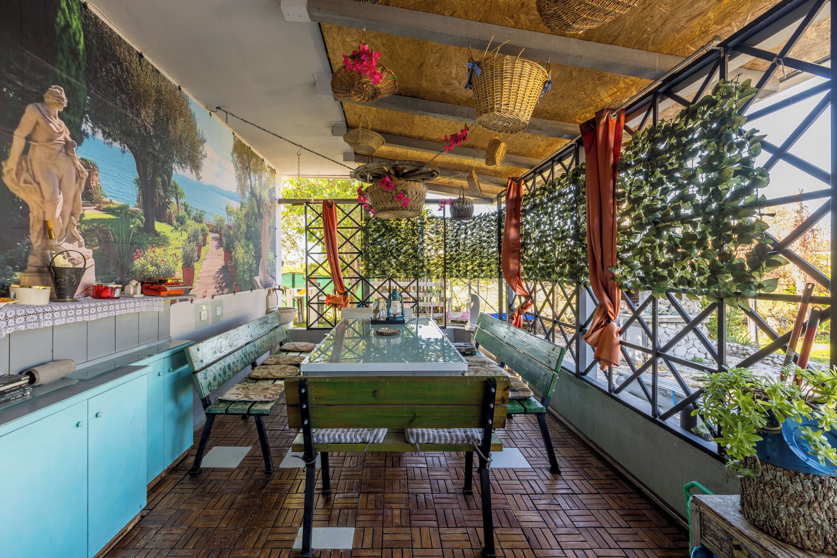 Un restaurant décoré d’une fresque murale, agrémenté de paniers en osier et doté d’un banc en bois.
