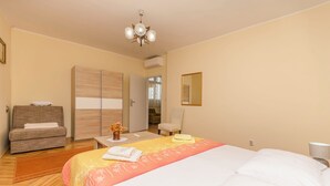 A hotel room with a bed, a sofa, a desk, and a wardrobe. - Apartment Goran Center (Vodice)