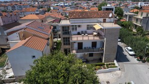 A multi-story residential building with balconies, a garden area, and a street view. - Apartment Goran Center (Vodice)