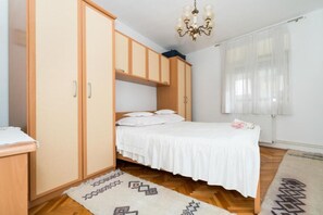 A bedroom with a bed, wardrobe, and a chandelier. - Apartment Zeljka (Dugi Rat)
