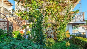 A lush garden with a variety of plants and a metal gate. - Apartment Zeljka (Dugi Rat)