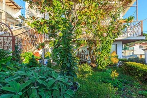 A lush garden with a variety of plants and a metal gate. - Apartment Zeljka (Dugi Rat)