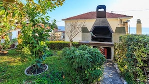A house with a barbecue area, surrounded by greenery and a view of the sea. - Apartment Zeljka (Dugi Rat)