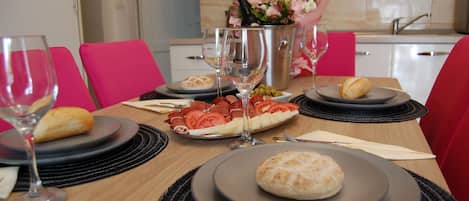 A dining table set with plates, glasses, and a bouquet of flowers.