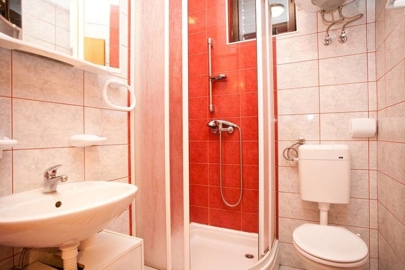 A bathroom with a sink, toilet, and shower.