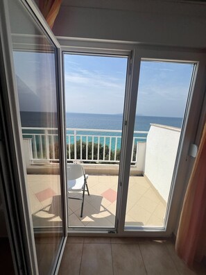 A balcony with a view of the sea, a white chair, and a tiled floor. - Apartments Klara (Gradac)