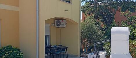 Un bâtiment à deux étages doté d’un espace extérieur aménagé pour s’asseoir et d’une terrasse couverte.