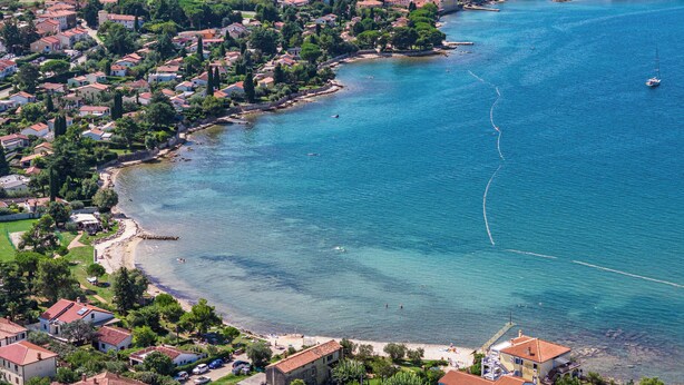 A coastal town with houses along the shoreline, a clear blue sea, and a small beach area. - Apartments Rondine (Brtonigla)