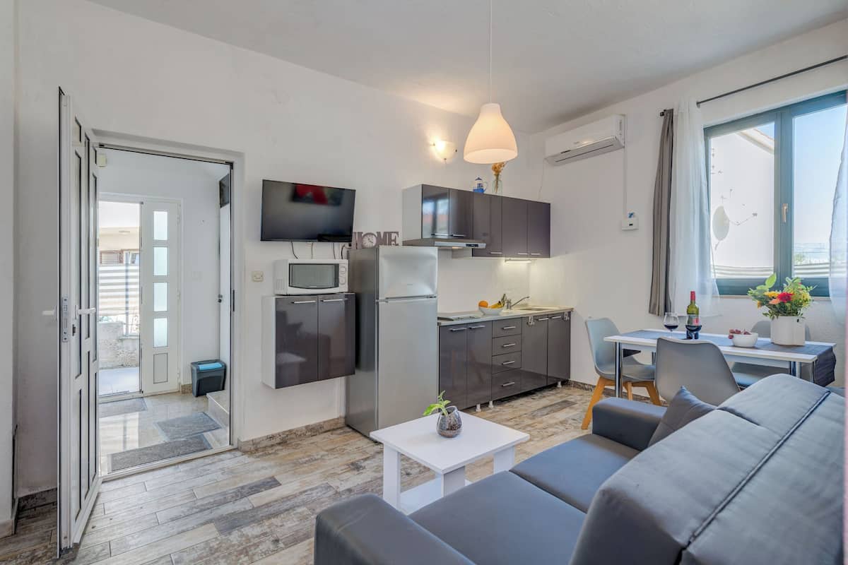 A compact living space with a kitchenette, a dining area, and a seating area.