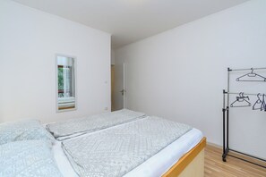 Une chambre à coucher avec un lit, une fenêtre et un portant à vêtements.