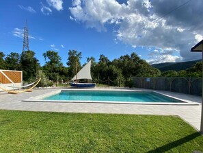 Una piscina al aire libre, sillones reclinables de piscina