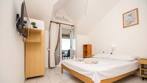 A bedroom with a bed, a TV mounted on the wall, a wooden wardrobe, a desk, and a chair. - Apartments Nada (Murter-Kornati)
