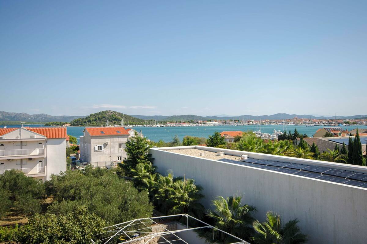 A coastal town with buildings, a marina, and a clear sky.
