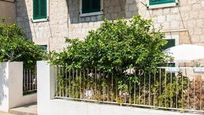 A two-story building with a balcony, stone facade, and green shutters. - Apartments Centre In Stone House (Split)